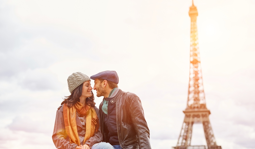 Young couple sitting together in front of the Eiffel Tower
