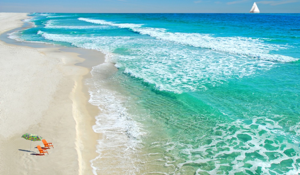 Empty beach chairs on deserted beach with sailboat, destination to avoid crowd