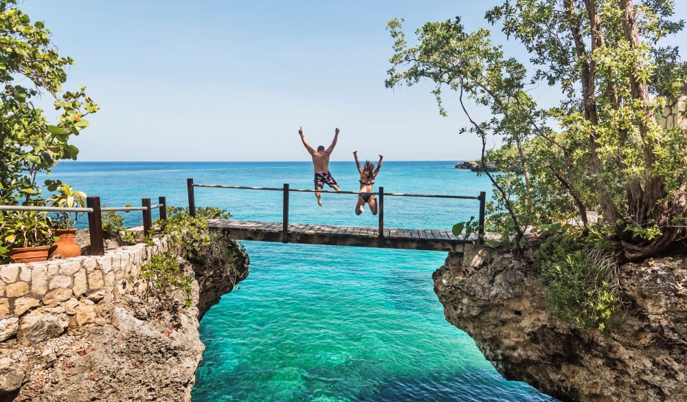 Jamaica, Negril, People jumping into ocean from footbridge