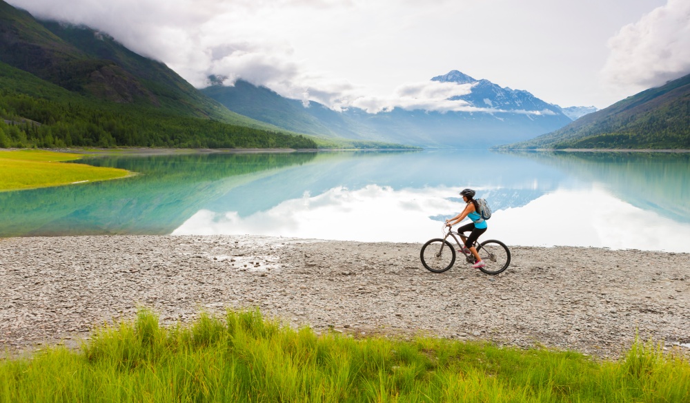  woman riding bicycle near lake, destination to avoid crowds