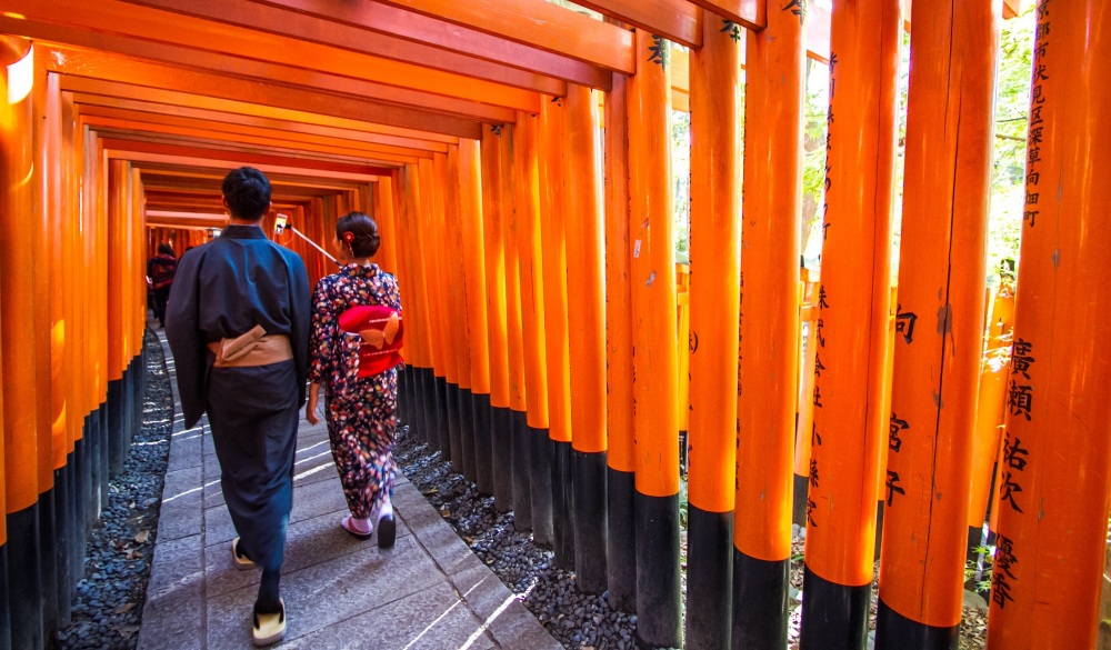 Tourists admiring the structure of Fushimi Inari Taisha Shrine.