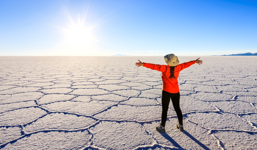 Female tourist on Salar de Uyuni, Altiplano, Bolivia, ultimate travel bucket list