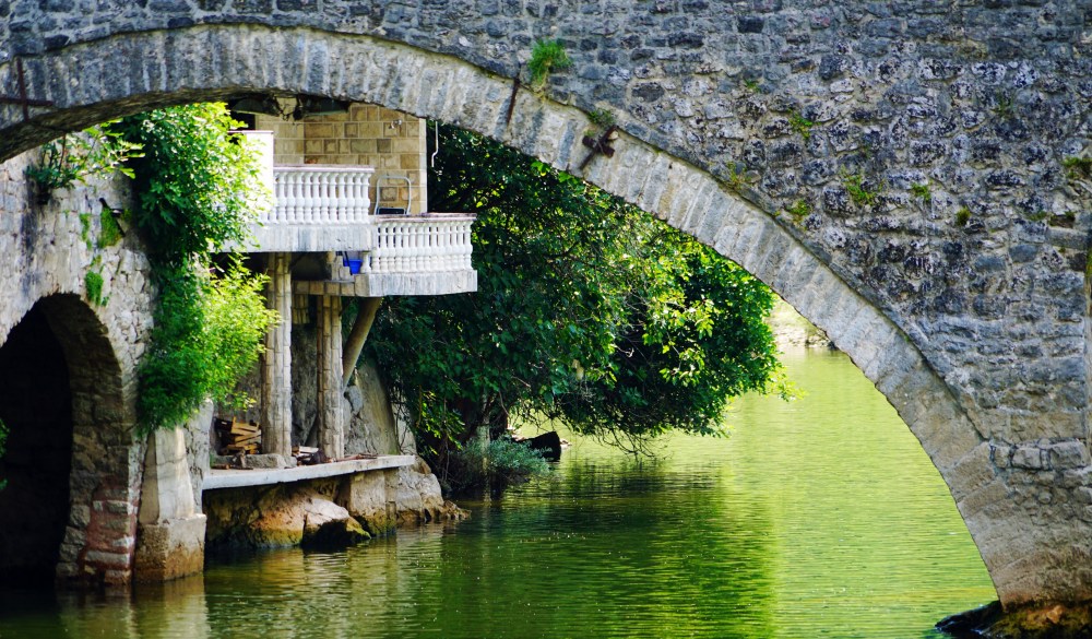 Arch Bridge Over River In Park, travel gems in europe