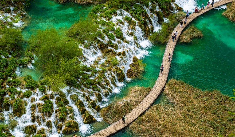 High Angle View Of People Walking On Boardwalk Over Water At Plitvice Lakes National Park, best lake getaways