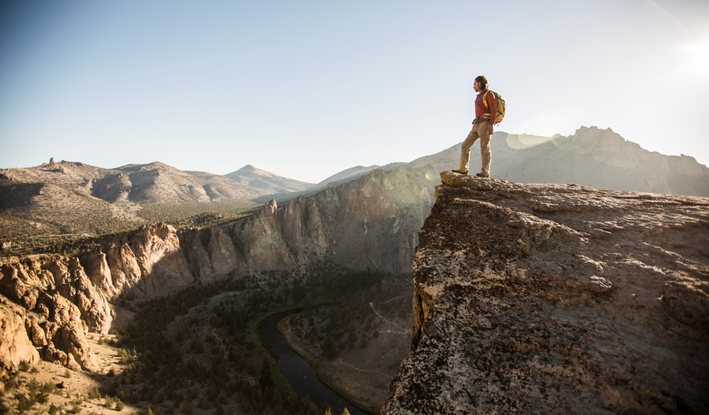 A man hiking a scenic trail overlooking a river in Smith Rock., best hikes in the US