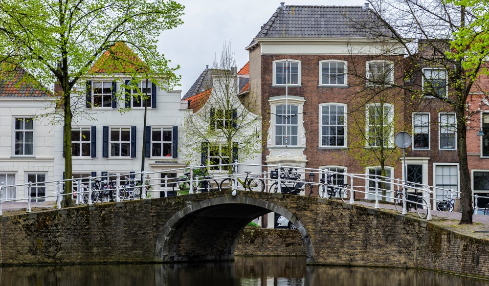 Arch Bridge Over River Amidst Buildings In City