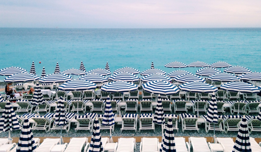 Deck Chairs And Parasols Arranged By Sea Against Sky