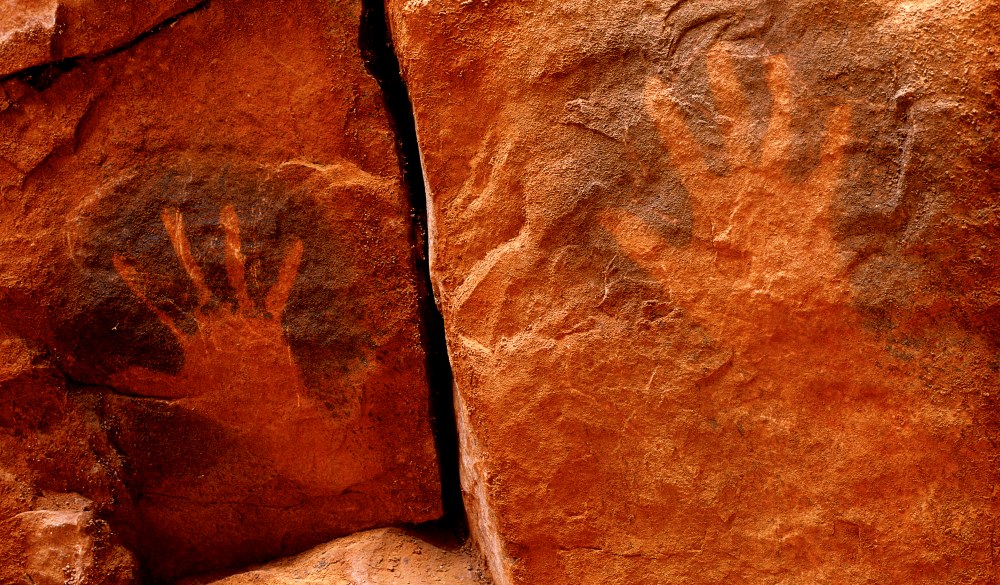Aboriginal hand stencils on cave wall. Watarrka National Park, Northern Territory, Australia., iconic Australian road trip destinations