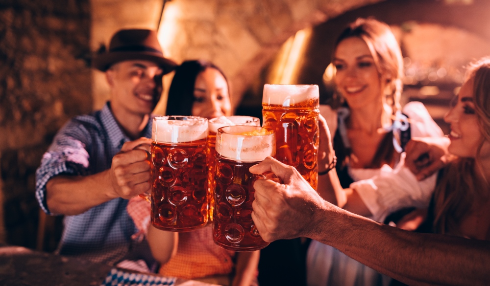 Happy friends celebrating Oktoberfest and toasting with beer