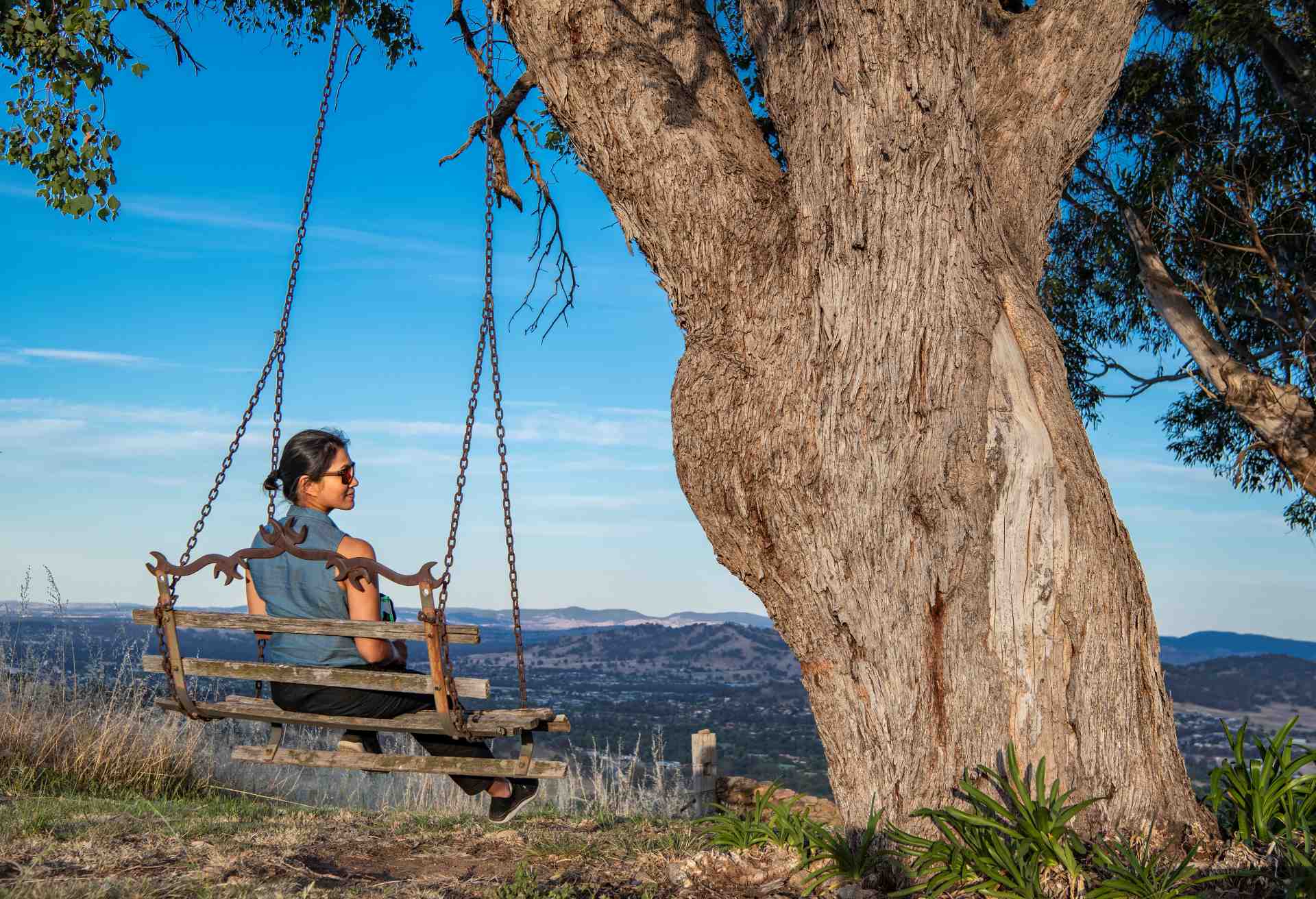 woman sitting on swing seat overlooking the bush in New South Wales