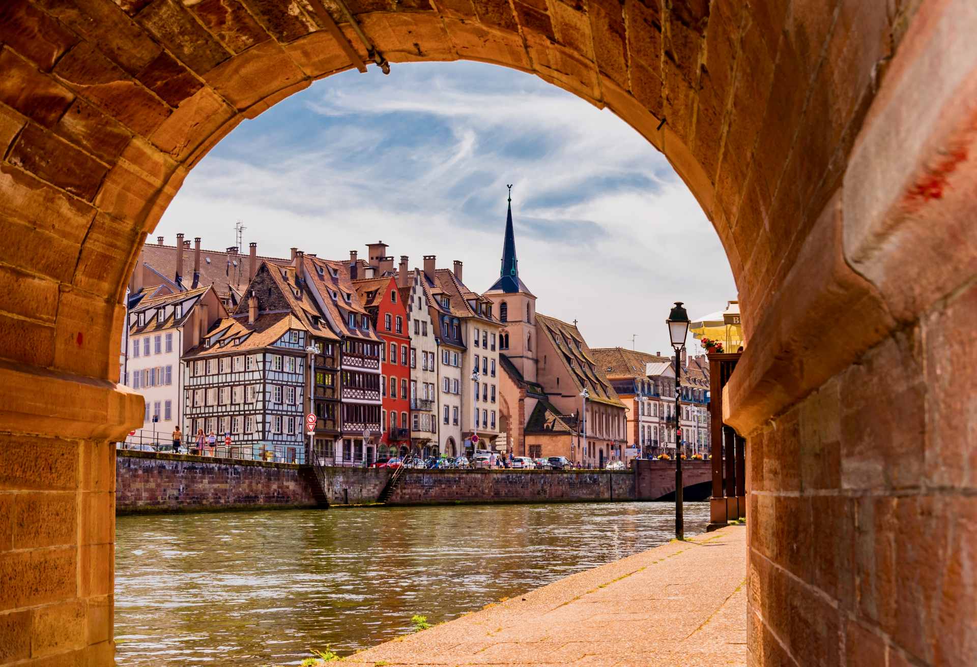 Buildings By Canal Seen Through Archway In City