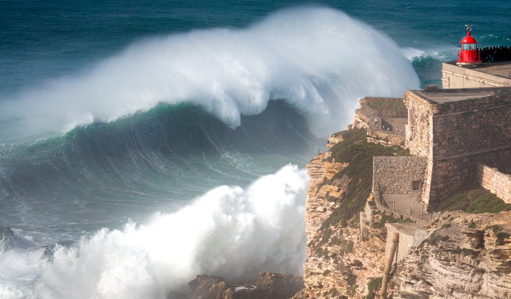 giant wave crashing into cliff, destination for portugal road trip