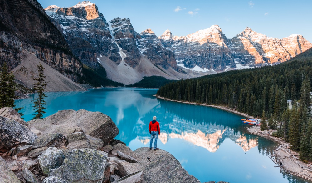 Man at Moraine lake at sunrise, Banff, Canada