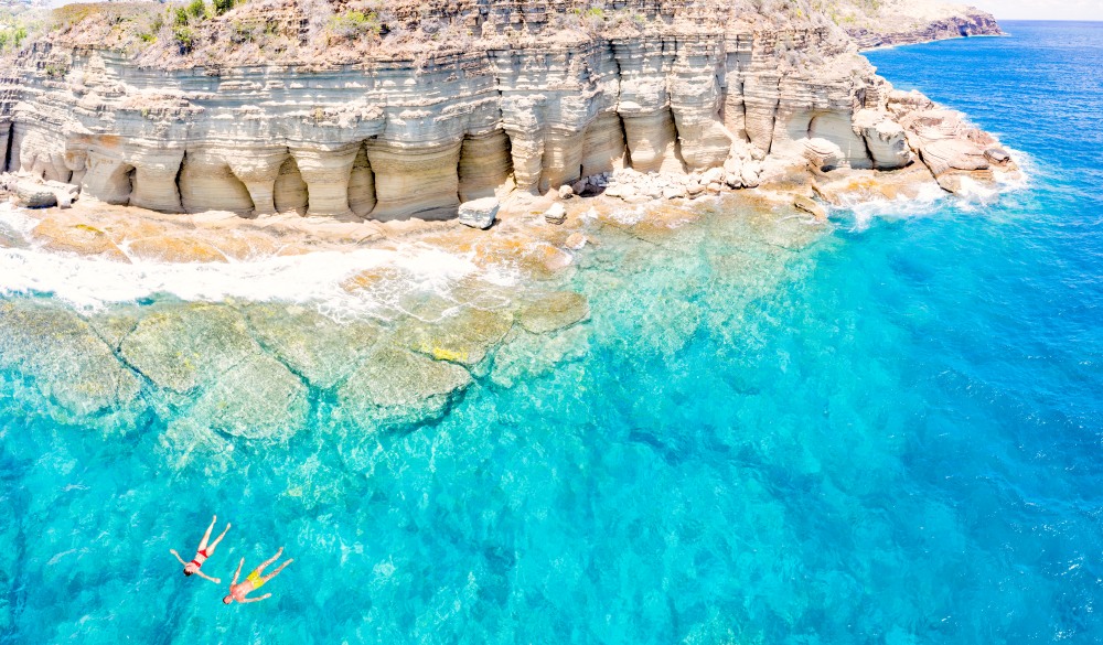 Couple floating in sea, Pillar of Hercules, Antigua, destination for a crowd-free vacation