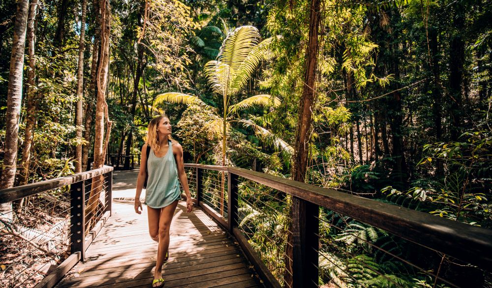 Young woman walking through the woodland area, destination for great hikes in australia