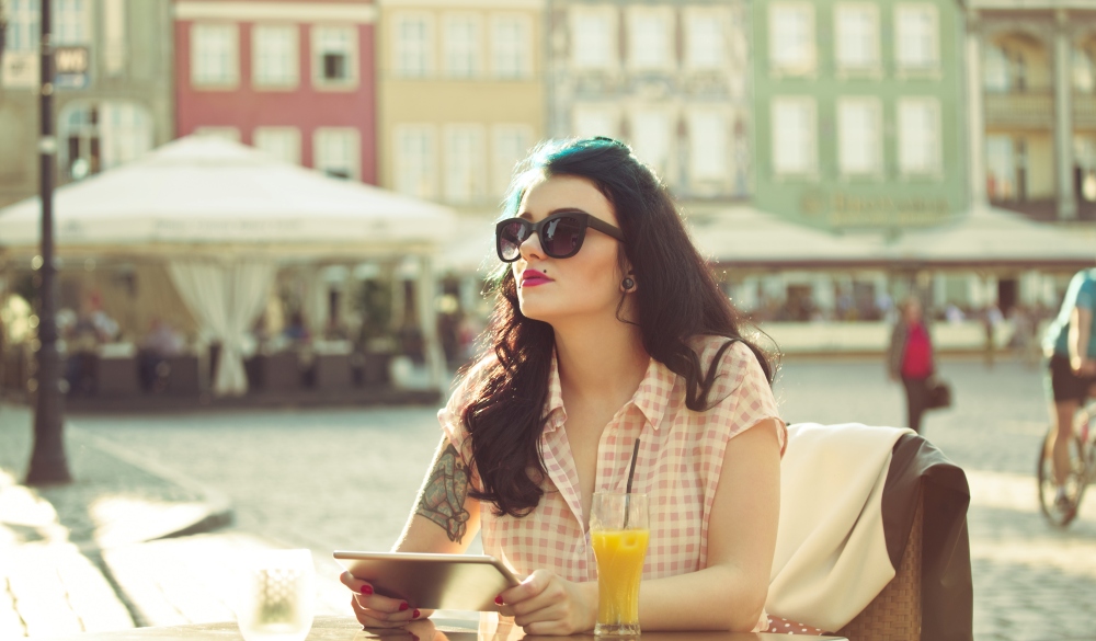 Young woman using a digital tablet in the outdoor restaurant