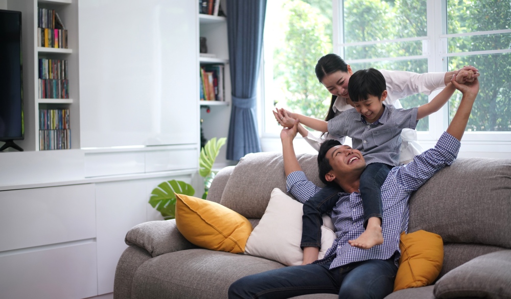 Asian parents playing with son in living room