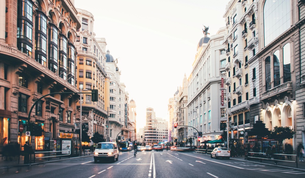 Vehicles On Road Along Buildings