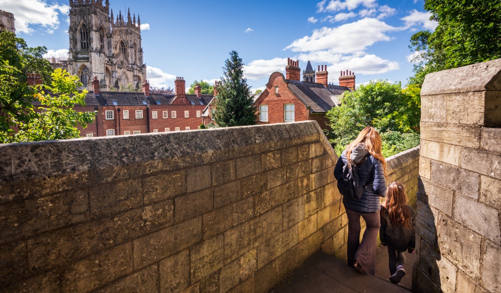 Tourists walking along York's city walls in England