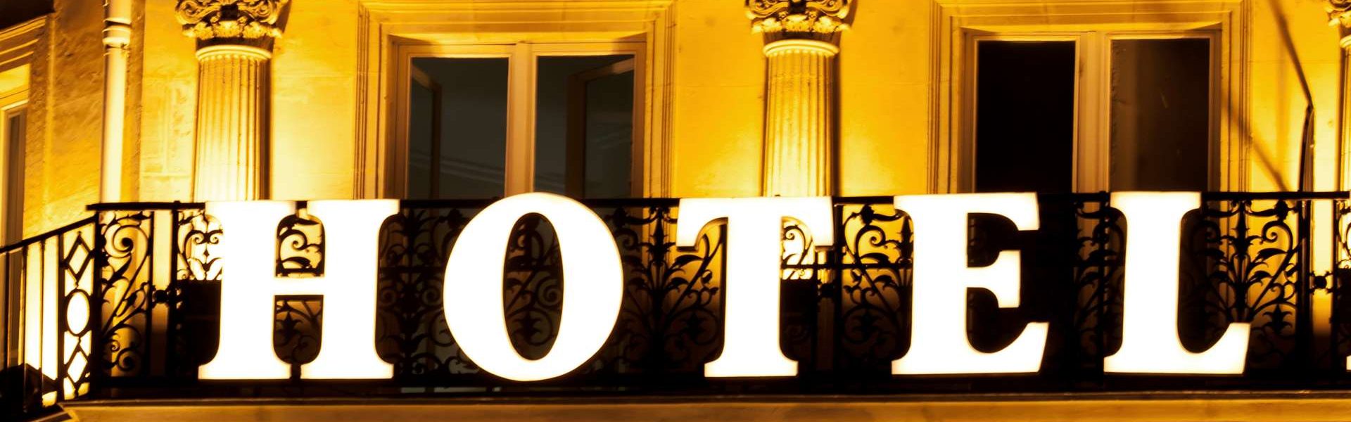 Brightly lit HOTEL sign on a hotel balcony