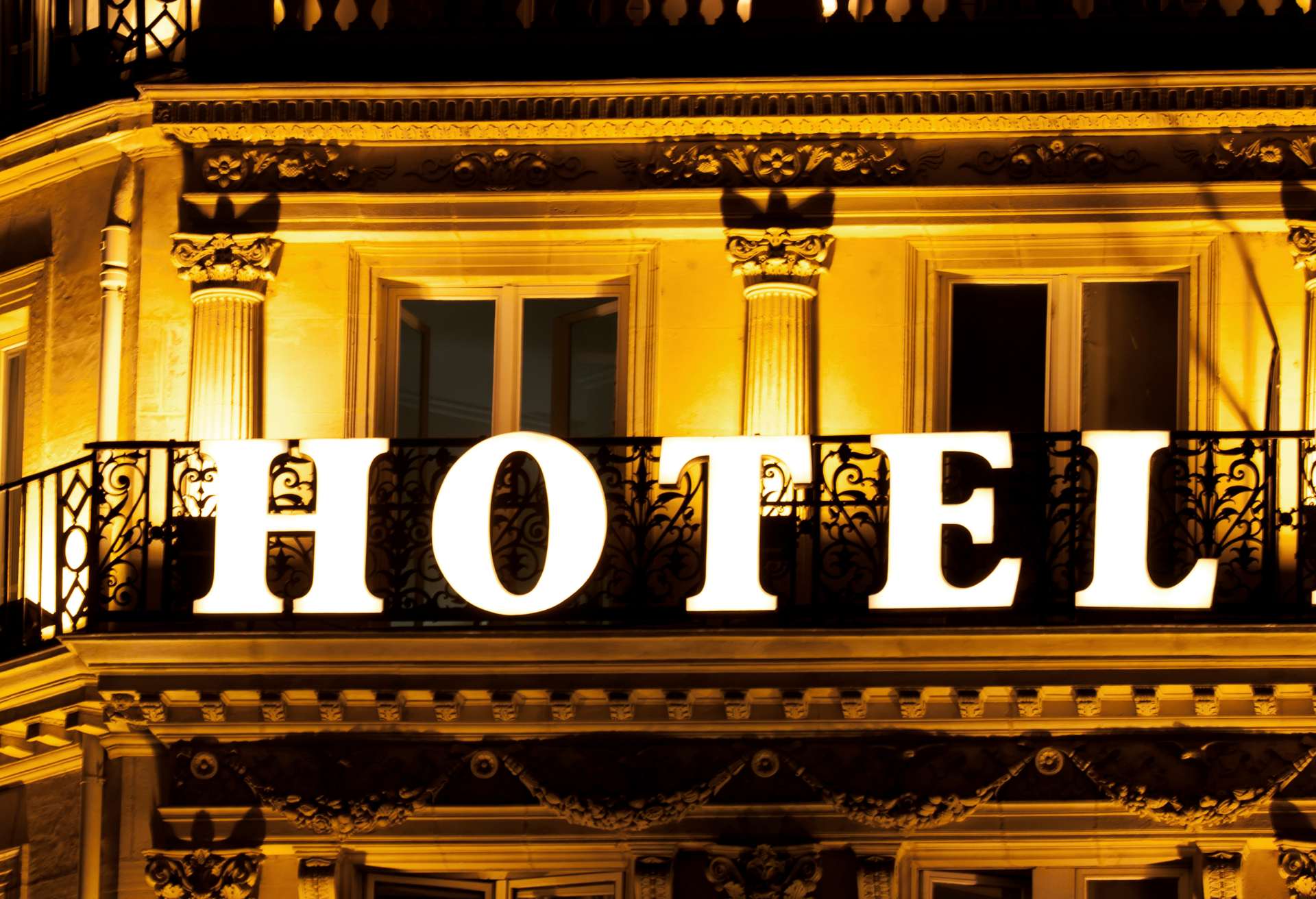 Brightly lit HOTEL sign on a hotel balcony