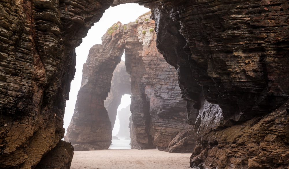 Natural rock arches on Cathedrals beach in low tide, Spain, destination for Spain road trip