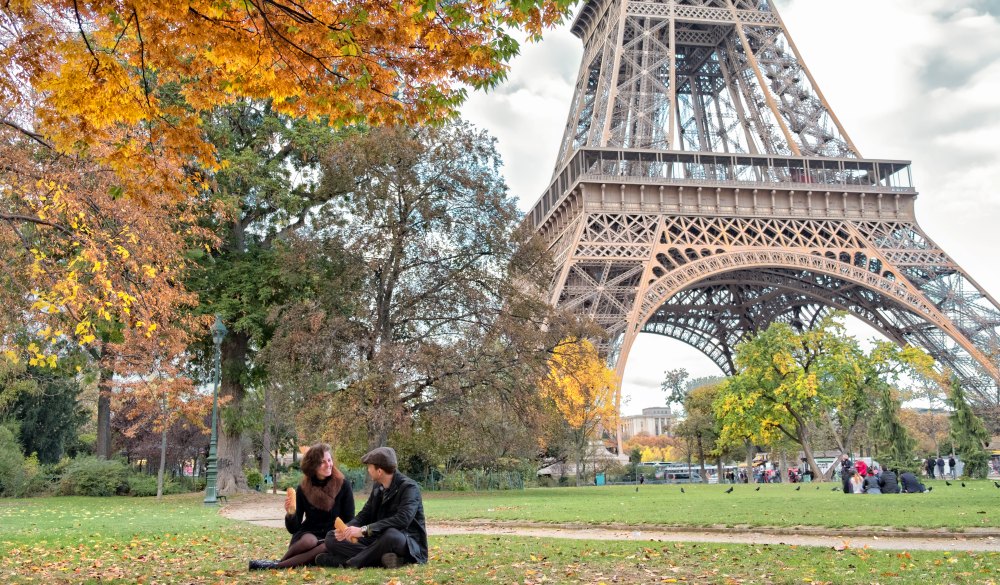 Couple relaxes at picnic by Eiffel Tower, France
