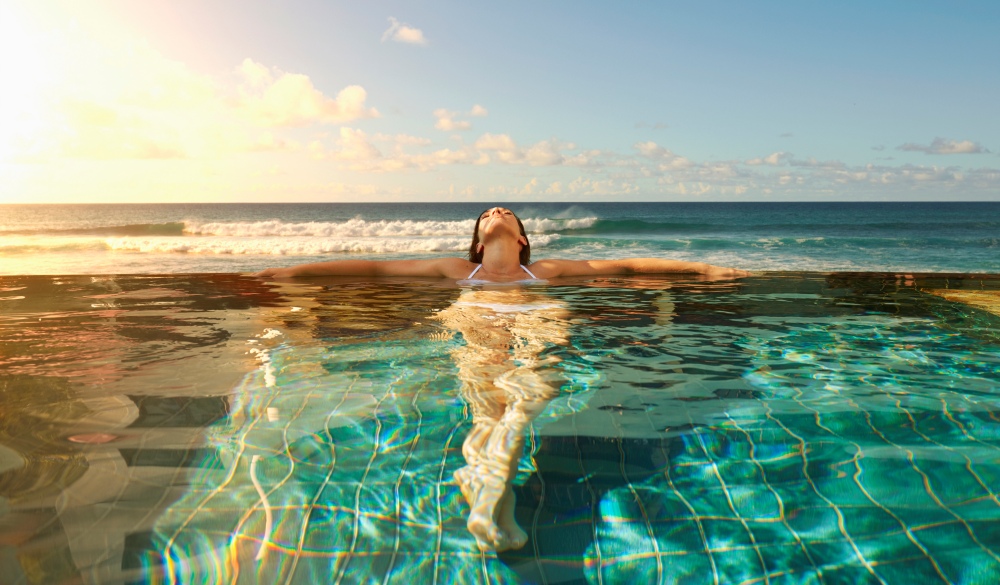 Pacific Islander woman laying in swimming pool