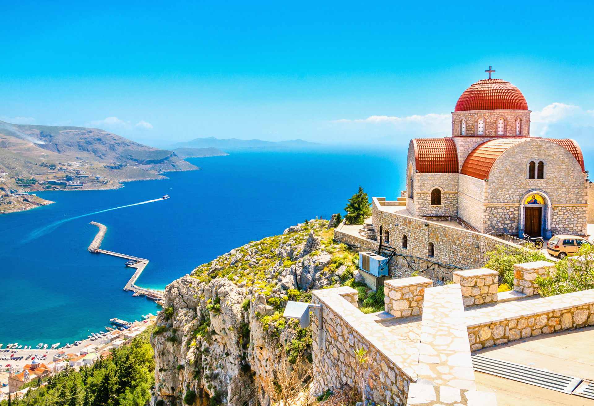 Remote church with red roofing on cliff, Greece