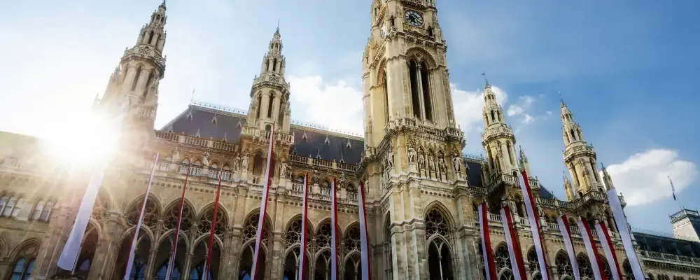 The Wiener Rathaus (Vienna City Hall, Austria) at sunset, with austrian flags over the facade