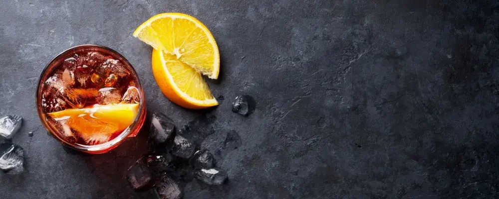 Negroni cocktail on dark stone table. Top view with space for your text