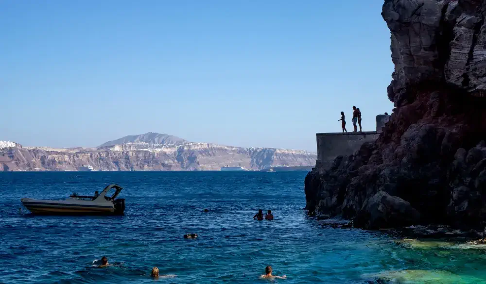 Cliff diving and swimming in Santorini Oia Amoudi / Ammoudi bay; Shutterstock ID 1404757835