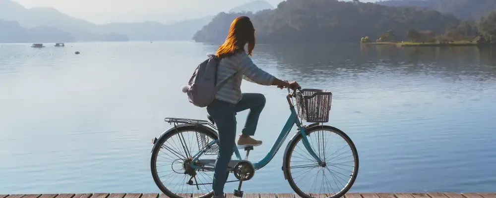 Young woman riding bicycle on Sun Moon lake bike trail, Travel lifestyle concept