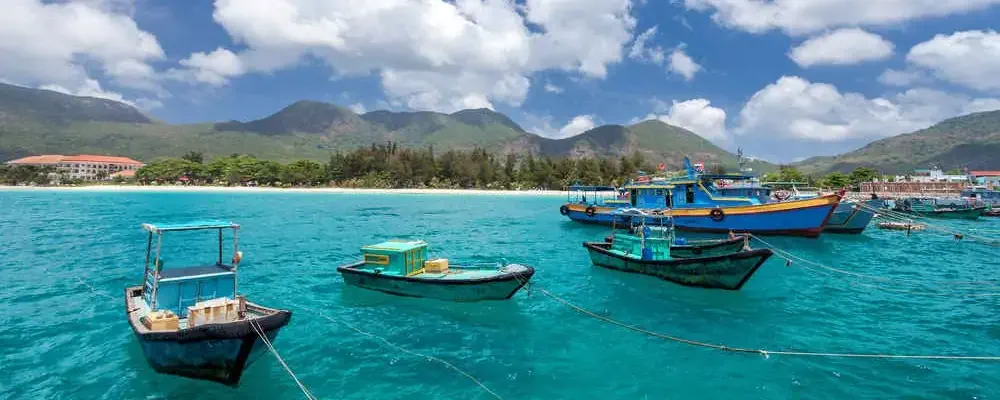 Vietnamese fishing boats on a tropical Con Dao Island. View from the pier in the direction of a beach with white sand.