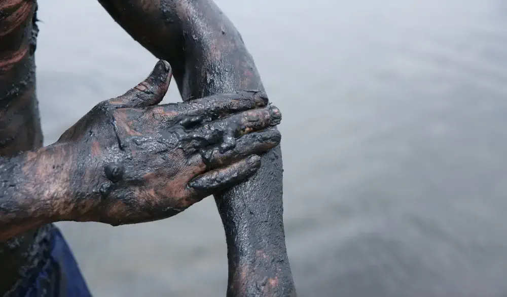 mud treatment in mud baths. smearing healing mud on the arm close up with copy space; Shutterstock ID 1445987318