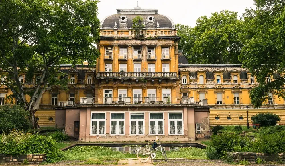 1800-squaremetre park with trees, many of wich are centuries old and the facade of the historical Lukacs Termal Bath building with the medicinal bath section and the indoor swimming pool in Budapest.; Shutterstock ID 1424896898