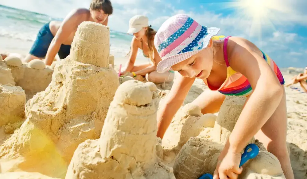 Young happy family building a sandcastle.