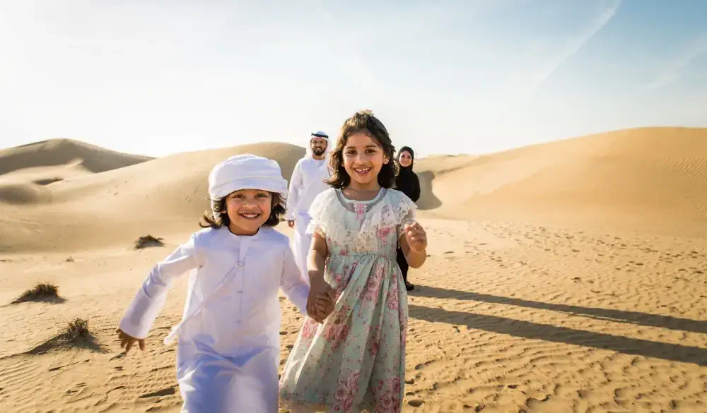 Arabian family with kids having fun in the desert - Parents and children celebrating holiday in the Dubai desrt