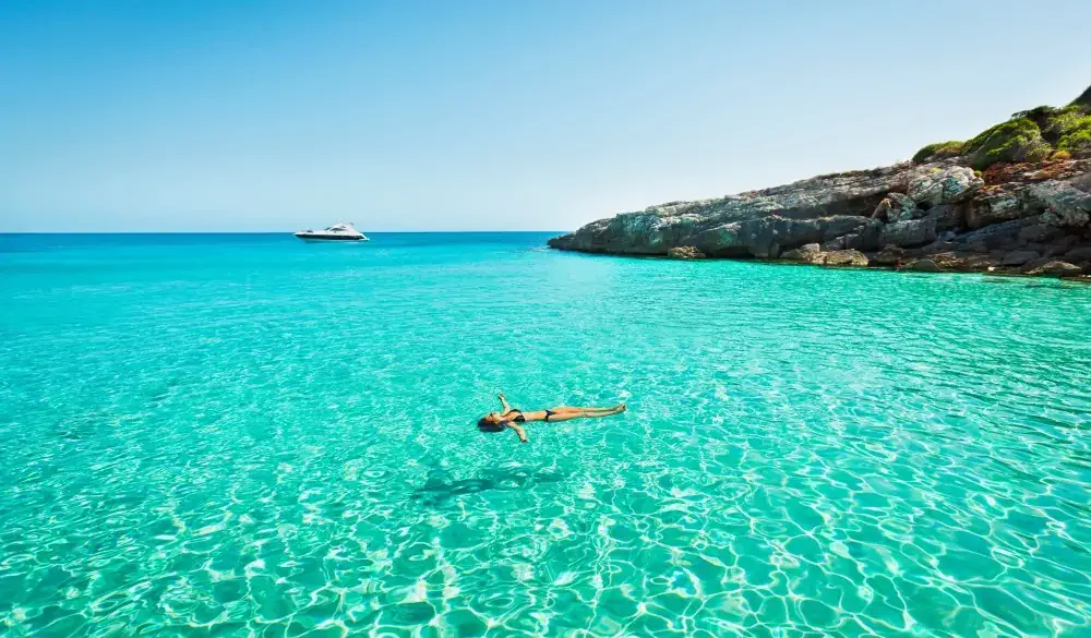 Idyllic holidays: girl floating in fresh clean turquoise water.