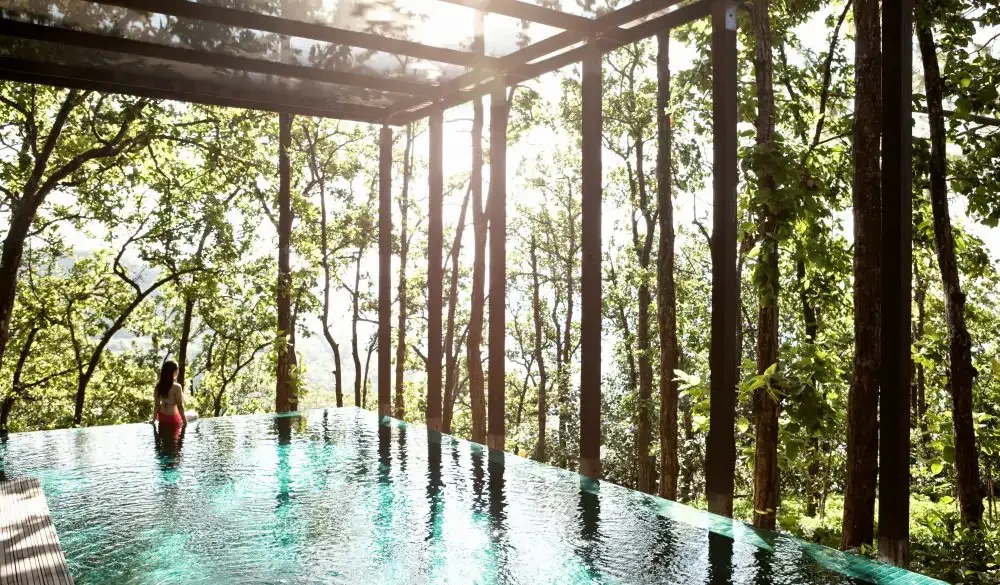 A woman wades in the pool of the Ganga Pool Villa at Ananda in the Himalayas, The Palace Estate, Narendra Nagar, Tehri Garhwal, Uttarakhand, India. The Ganga Pool Villa is a one-bedroom private villa with its own infinity pool.