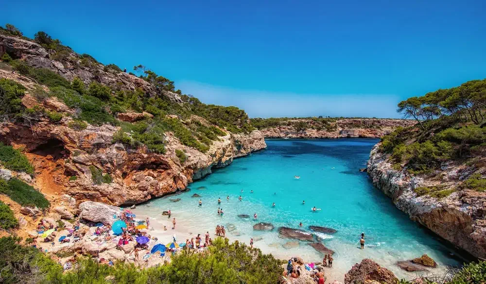 A small, sandy beach with shallow turquoise waters.