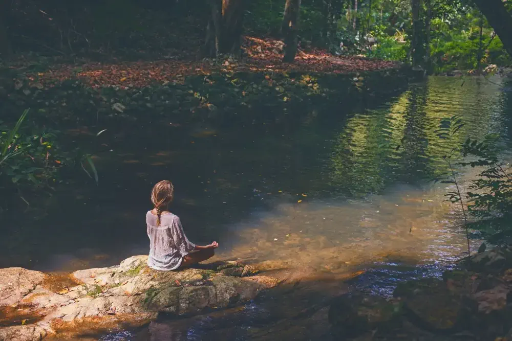 Woman mediting in tropical forest