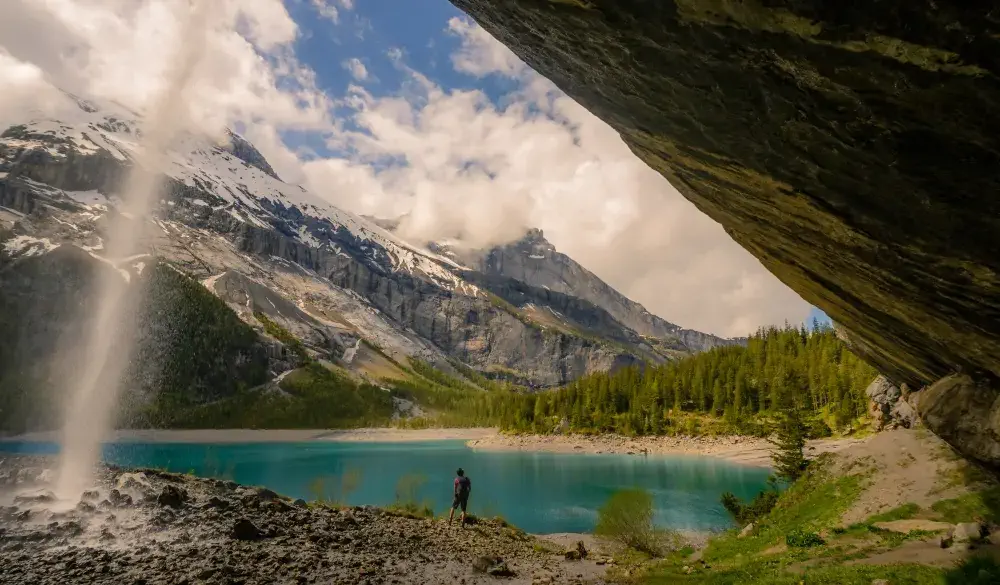 Hiking beneath a waterfall in the Swiss alps